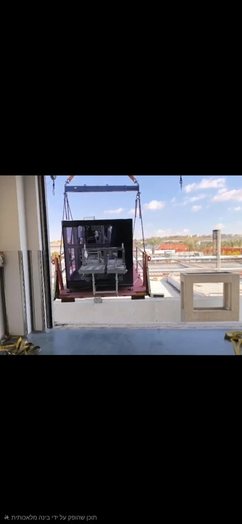 ציוד תעשייתי מונף דרך פתח גבוה בחזית מבנה
